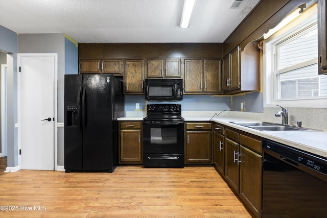716 Shadowridge Rd, Jacksonville, NC 28546 - kitchen with black appliances, a sink, light countertops, light wood finished floors, and dark brown cabinetry