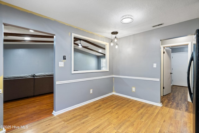 716 Shadowridge Rd, Jacksonville, NC 28546 - empty room with wood finished floors, a textured ceiling, ceiling fan, and baseboards