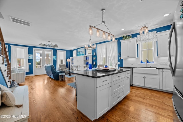 233 E Water St, Washington, NC 27889 - kitchen featuring a sink, open floor plan, dark countertops, stainless steel appliances, and white cabinets
