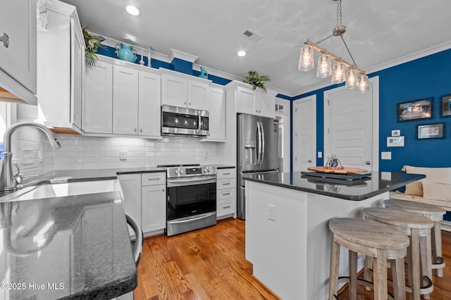 233 E Water St, Washington, NC 27889 - kitchen featuring stainless steel appliances, a sink, a center island, light wood-style floors, and crown molding