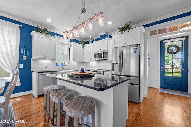 233 E Water St, Washington, NC 27889 - kitchen featuring stainless steel appliances, a breakfast bar, a kitchen island, baseboards, and white cabinetry
