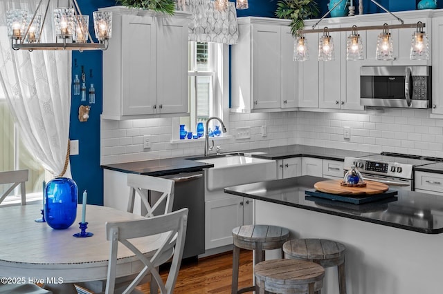 233 E Water St, Washington, NC 27889 - kitchen featuring stainless steel appliances, a sink, dark countertops, and a chandelier