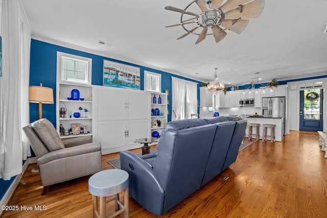 233 E Water St, Washington, NC 27889 - living room featuring ceiling fan, ornamental molding, light wood finished floors, and a chandelier