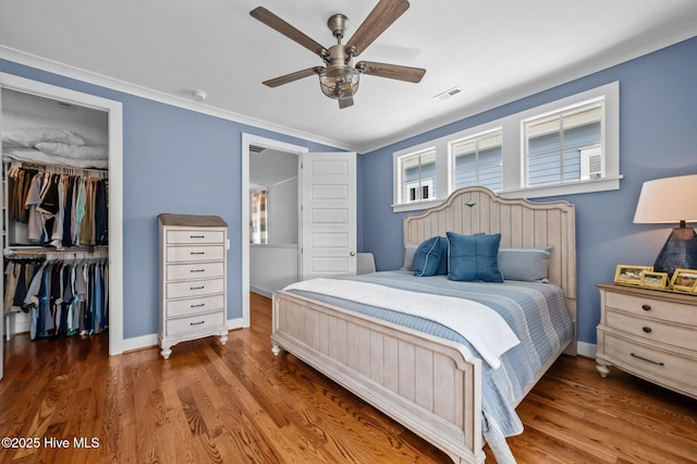 233 E Water St, Washington, NC 27889 - bedroom with a closet, wood finished floors, a walk in closet, a ceiling fan, and baseboards