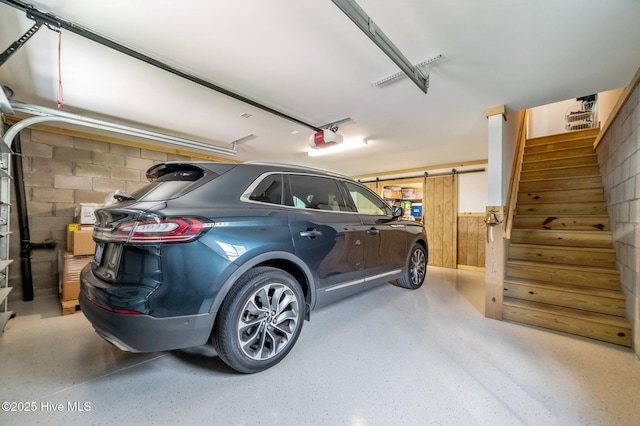 233 E Water St, Washington, NC 27889 - garage featuring a garage door opener, wood walls, and wainscoting
