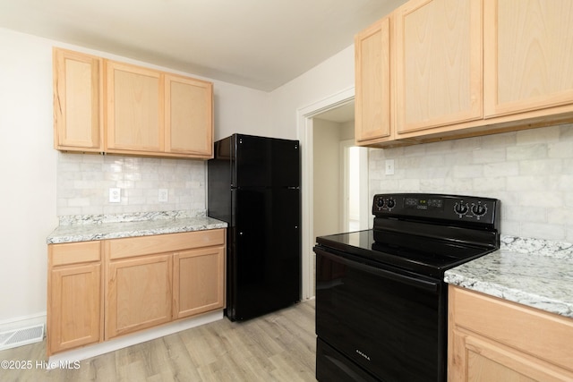 808 Cabarrus St, Edenton, NC 27932 - kitchen with black appliances, light brown cabinetry, backsplash, light wood-style flooring, and light stone counters