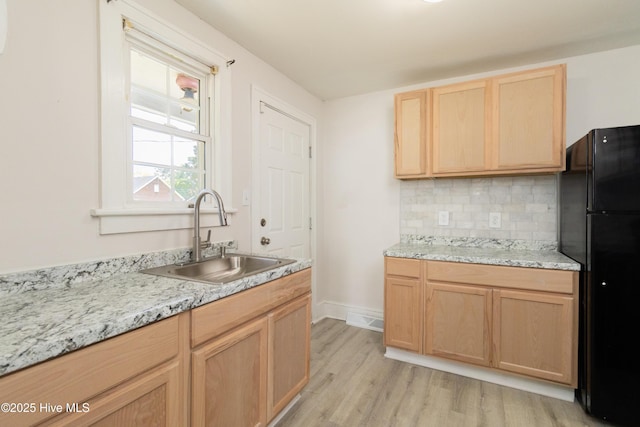 808 Cabarrus St, Edenton, NC 27932 - kitchen with a sink, freestanding refrigerator, light brown cabinetry, backsplash, and light wood-type flooring