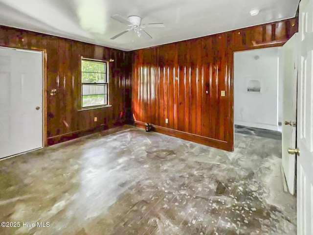 101 W Pearl St, Aulander, NC 27805 - empty room with a ceiling fan, wooden walls, and concrete flooring