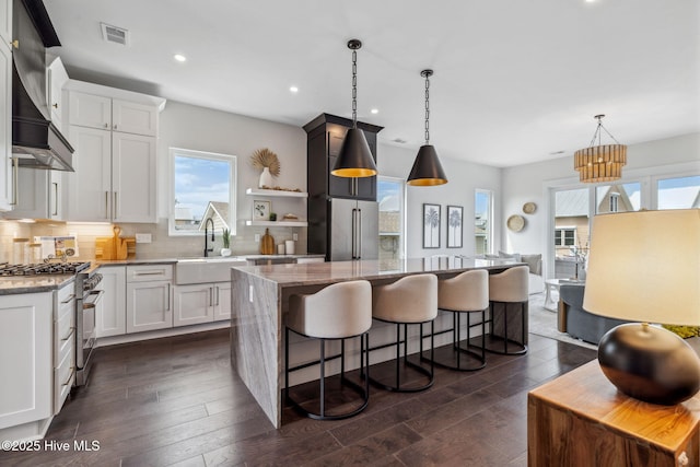 221 Georgia Ave, Carolina Beach, NC 28428 - kitchen featuring premium appliances, a sink, wall chimney range hood, a kitchen island, and healthy amount of natural light