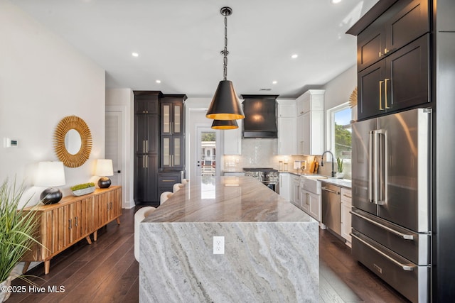 221 Georgia Ave, Carolina Beach, NC 28428 - kitchen featuring premium appliances, a sink, light stone counters, tasteful backsplash, and a center island