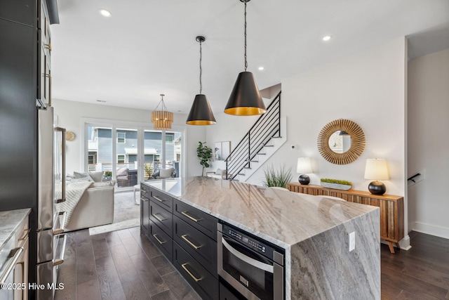 221 Georgia Ave, Carolina Beach, NC 28428 - kitchen featuring dark wood-style floors, open floor plan, dark cabinetry, a center island, and built in microwave