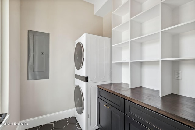 221 Georgia Ave, Carolina Beach, NC 28428 - laundry area with stacked washer / dryer, cabinet space, electric panel, and dark tile patterned floors