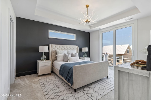 221 Georgia Ave, Carolina Beach, NC 28428 - bedroom featuring a chandelier, a tray ceiling, access to exterior, and multiple windows