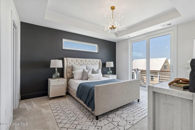 221 Georgia Ave, Carolina Beach, NC 28428 - bedroom featuring a chandelier, a tray ceiling, access to exterior, and multiple windows