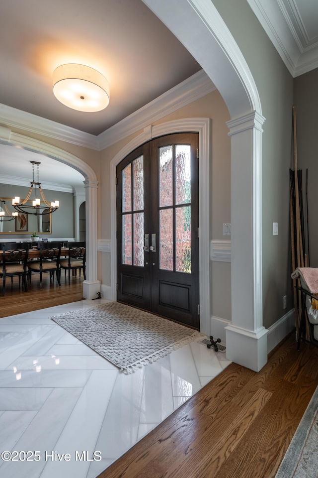 509 Westminster Cir, Greenville, NC 27858 - foyer featuring arched walkways, ornamental molding, french doors, ornate columns, and a chandelier