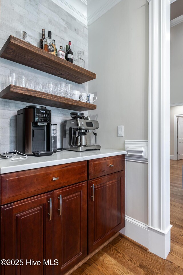 509 Westminster Cir, Greenville, NC 27858 - bar area with decorative columns, ornamental molding, tasteful backsplash, and light wood-style flooring