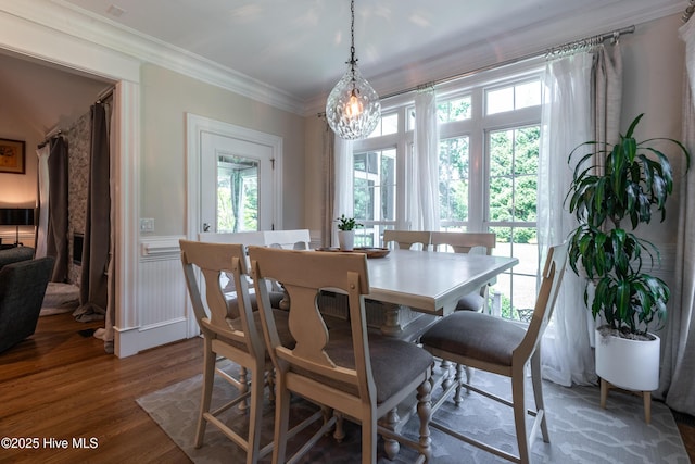 509 Westminster Cir, Greenville, NC 27858 - dining area featuring wood finished floors, a chandelier, crown molding, and a wainscoted wall