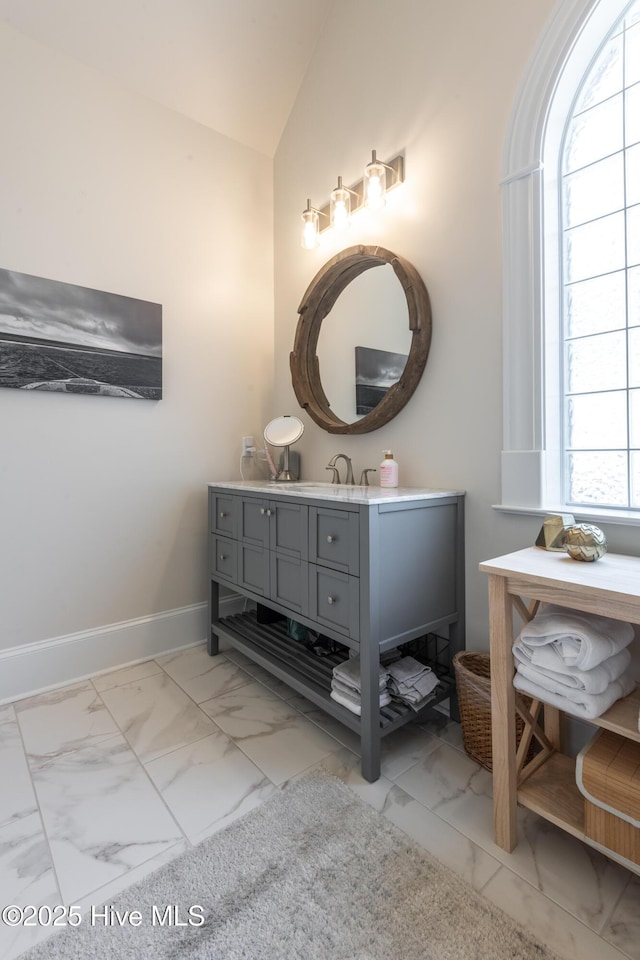 509 Westminster Cir, Greenville, NC 27858 - bathroom featuring marble finish flooring, vanity, lofted ceiling, and baseboards