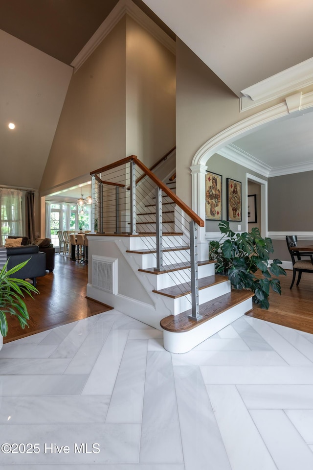 509 Westminster Cir, Greenville, NC 27858 - staircase featuring ornamental molding, wood finished floors, high vaulted ceiling, baseboards, and recessed lighting