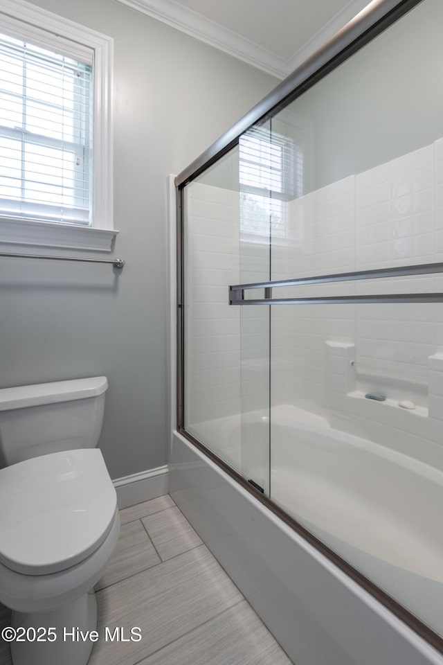 509 Westminster Cir, Greenville, NC 27858 - bathroom featuring tile patterned flooring, shower / bath combination with glass door, healthy amount of natural light, toilet, and crown molding