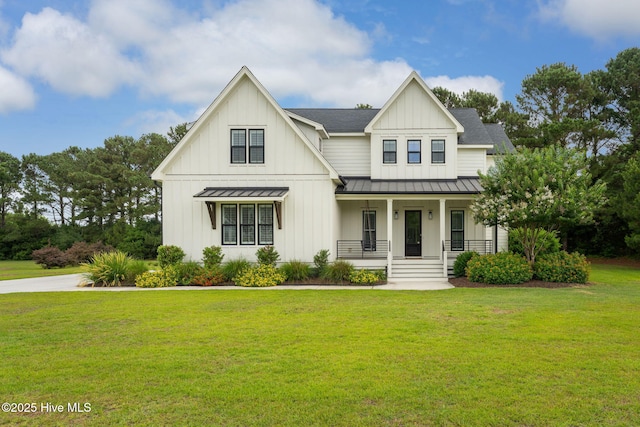204 N Sea Lily Ct, Hampstead, NC 28443 - modern inspired farmhouse with a standing seam roof, covered porch, a front lawn, metal roof, and board and batten siding