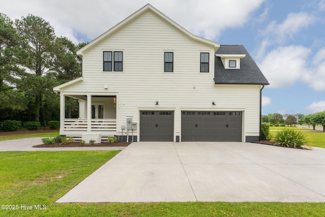 204 N Sea Lily Ct, Hampstead, NC 28443 - view of front facade with covered porch, an attached garage, concrete driveway, and a front lawn