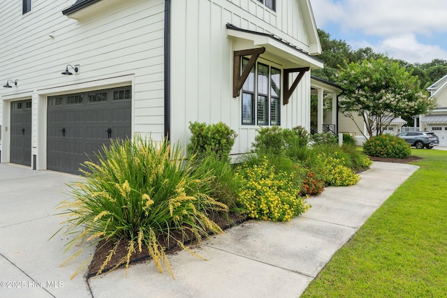 204 N Sea Lily Ct, Hampstead, NC 28443 - view of side of property featuring board and batten siding, driveway, a garage, and a yard
