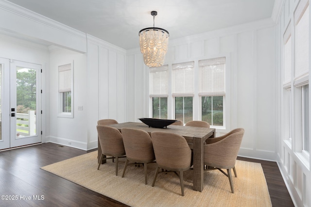 204 N Sea Lily Ct, Hampstead, NC 28443 - dining area with a chandelier, a decorative wall, ornamental molding, dark wood-style flooring, and french doors