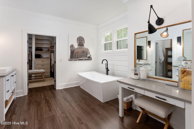 204 N Sea Lily Ct, Hampstead, NC 28443 - bathroom with a freestanding bath, vanity, a spacious closet, wood finished floors, and ornamental molding