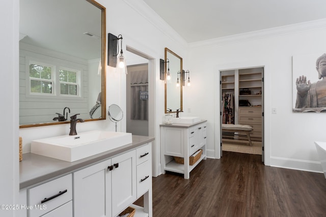 204 N Sea Lily Ct, Hampstead, NC 28443 - full bathroom with two vanities, ornamental molding, wood finished floors, a walk in closet, and a tub