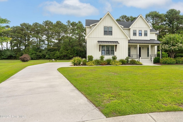 204 N Sea Lily Ct, Hampstead, NC 28443 - modern farmhouse with a standing seam roof, covered porch, board and batten siding, and a front lawn