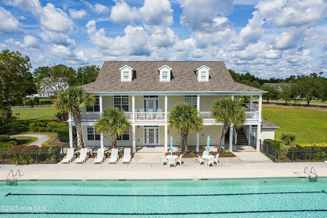 204 N Sea Lily Ct, Hampstead, NC 28443 - rear view of house with stairway, a patio, a community pool, and a shingled roof