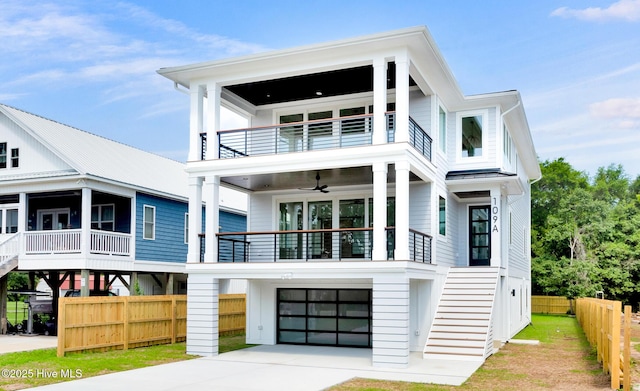 109 Broadview Ln, Hampstead, NC 28443 - coastal inspired home with a balcony, stairway, a garage, driveway, and metal roof