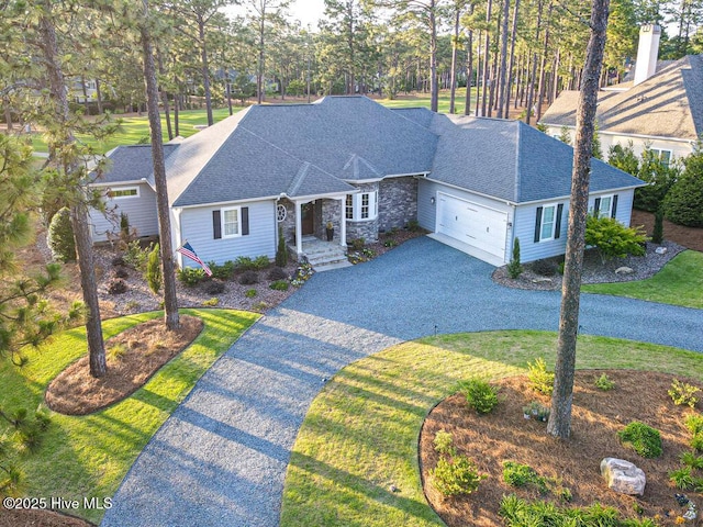 177 National Dr, Pinehurst, NC 28374 - view of front of property with asphalt driveway, a garage, a shingled roof, stone siding, and a front yard