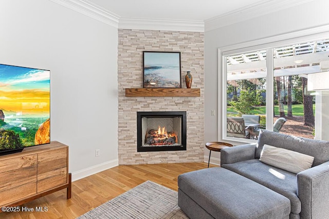 177 National Dr, Pinehurst, NC 28374 - living room featuring wood finished floors, ornamental molding, a stone fireplace, and baseboards