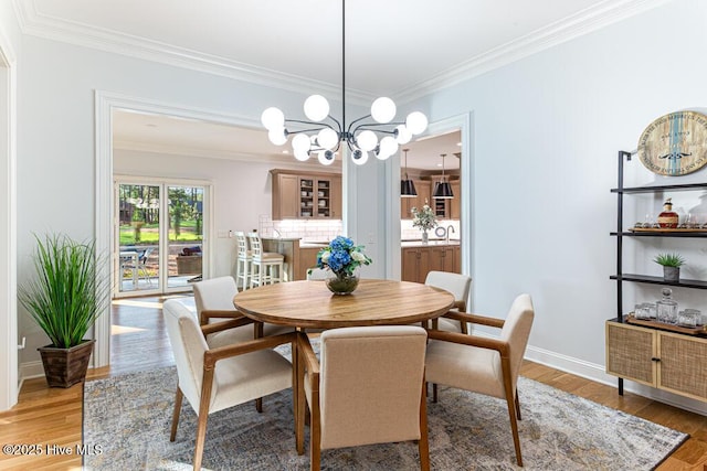 177 National Dr, Pinehurst, NC 28374 - dining room featuring ornamental molding, light wood-style floors, a chandelier, and baseboards