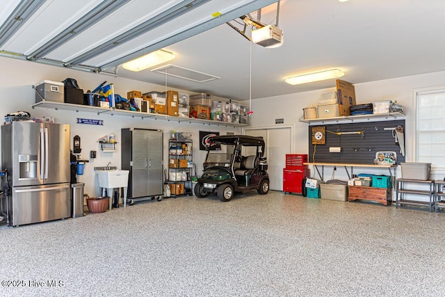 177 National Dr, Pinehurst, NC 28374 - garage with stainless steel fridge, a garage door opener, and a sink