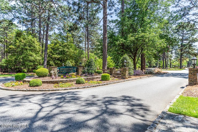 177 National Dr, Pinehurst, NC 28374 - view of asphalt street with street lighting, curbs, and view of wooded area
