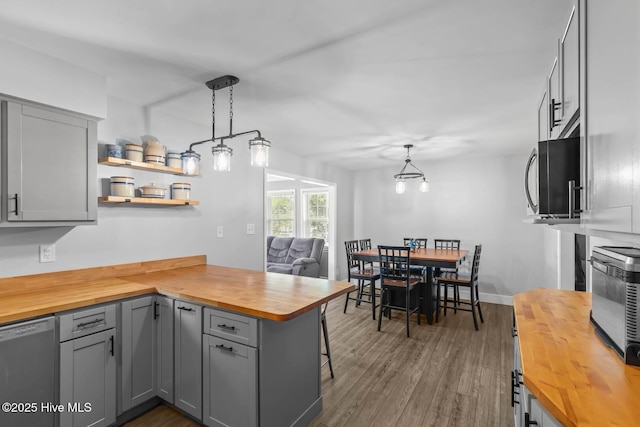 815 Gadwell Loop, Jacksonville, NC 28540 - kitchen featuring wooden counters, stainless steel appliances, gray cabinets, a peninsula, and dark wood-style flooring
