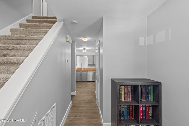 815 Gadwell Loop, Jacksonville, NC 28540 - hall with a sink, dark wood finished floors, baseboards, and stairway