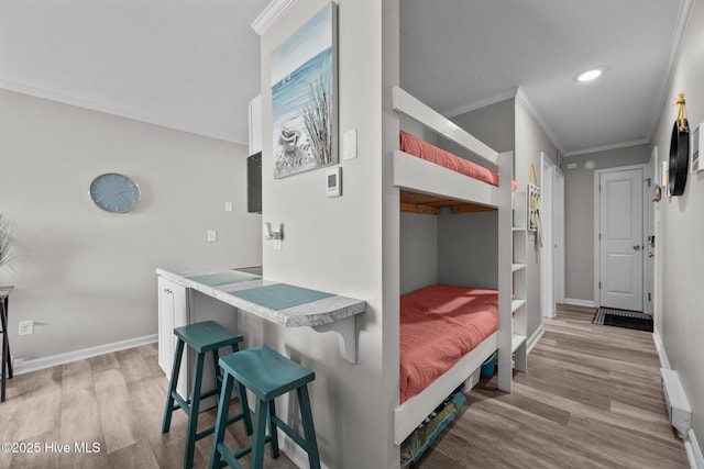bedroom with ornamental molding, light wood-style floors, baseboards, and recessed lighting