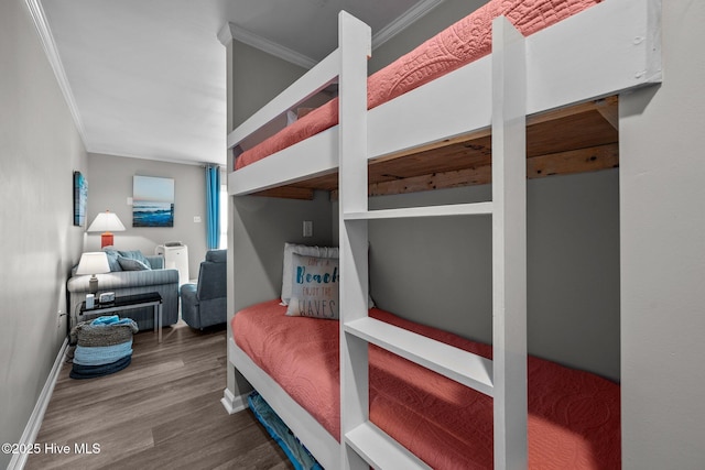 bedroom with ornamental molding, wood finished floors, and baseboards