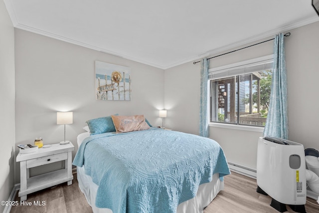 bedroom featuring crown molding, a baseboard heating unit, and wood finished floors