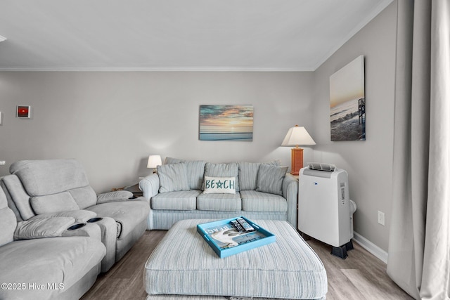 living room featuring light wood-style flooring, ornamental molding, and baseboards