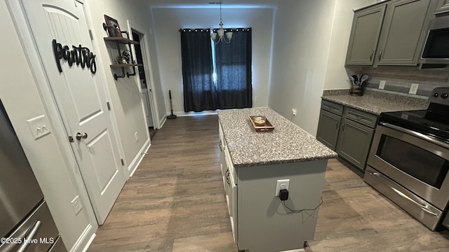 87 Strut Way, Rocky Point, NC 28457 - kitchen with appliances with stainless steel finishes, dark wood-style flooring, a chandelier, a center island, and light stone countertops