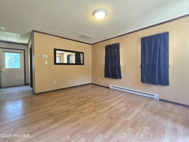 144 Micmac Trl, Hertford, NC 27944 - empty room with baseboard heating, wood finished floors, a textured ceiling, crown molding, and baseboards