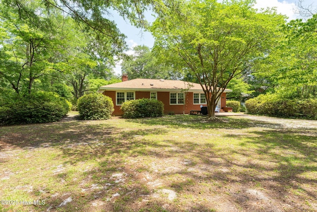 211 Spruce Cir, Wilmington, NC 28403 - rear view of property with a chimney, brick siding, and a lawn