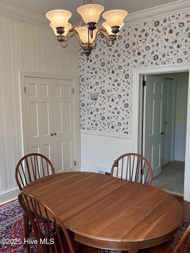 215 W Queen St, Edenton, NC 27932 - dining space with a chandelier, a wainscoted wall, and ornamental molding