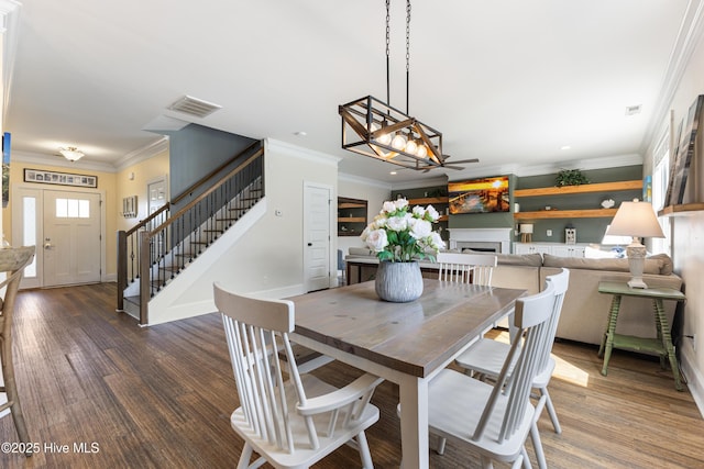 157 Heritage Way, Hampstead, NC 28443 - dining space with stairway, a fireplace, wood finished floors, ornamental molding, and a ceiling fan