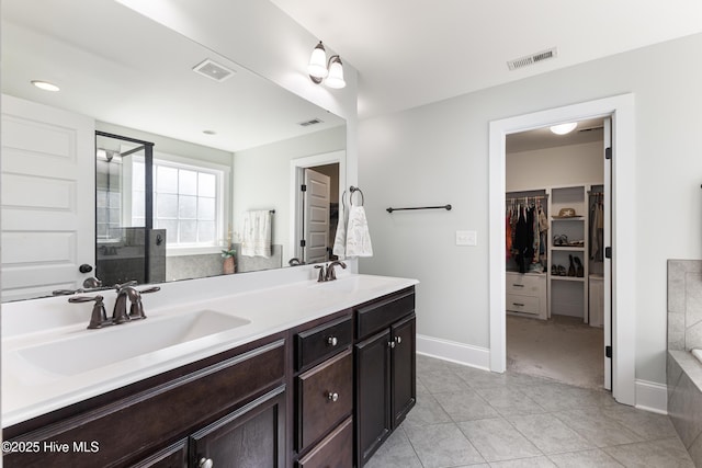 157 Heritage Way, Hampstead, NC 28443 - full bath with double vanity, a tub, a walk in closet, a stall shower, and tile patterned floors